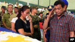 Presiden Filipina Rodrigo Duterte memberi hormat ke arah peti jenazah 15 tentara yang tewas dalam pertempuran dengan militan Abu Sayyaf di kota Zamboanga, Filipina selatan, Agustus 2016. 