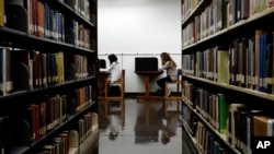 FILE - Students are seen studying in a library on the campus of California State University in Long Beach, California, Oct. 19, 2012. After factoring in age, gender, education and economic status, researchers found that readers lived two years longer than non-readers.