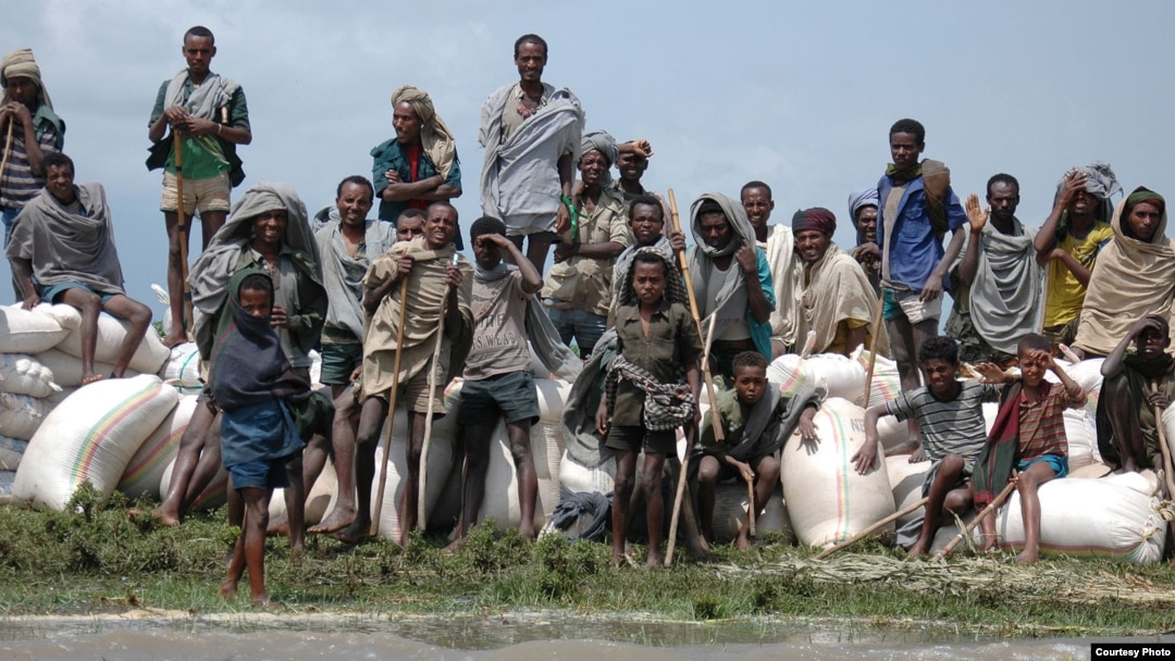 A crowd of stranded villagers gather on the banks of Ethiopia's Lake Tana (the source of the Blue Nile), as sacks of emergency food supplies are unloaded. Weeks of heavy rain have left more than 630 dead and 200,000 homeless and facing the spread of water
