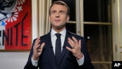 French President Emmanuel Macron, gestures as he poses for a photograph after the recording of his New Year's speech at the Elysee Palace, in Paris, Dec. 31, 2018. 