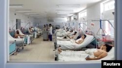 FILE - Afghan men who were injured in a recent attack in Kabul and Ghazni province, receive treatment at a hospital in Kabul, Afghanistan Aug. 18, 2018.