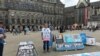 FILE - Abdurehim Gheni stands in demonstration with pictures of his relatives and other disappeared Uighurs, at Dam Square in Amsterdam in July. (Photo courtesy: Abdurehim Gheni)