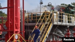 FILE - Employees work at a gas well of Ukraine's state energy company Naftogaz in the country's western Lviv region, Oct. 1, 2022.