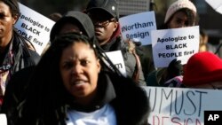 FILE - Demonstrators hold signs and chant outside the Governor's Mansion at the Capitol in Richmond, Va., Feb. 2, 2019. The demonstrators were calling for the resignation of Virginia Gov Ralph Northam. 