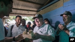 Howard Buffett receives presents during a visit, with Colombia's President Ivan Duque, right, to a farm in La Gabarra, Colombia. As a philanthropist, Buffett's priority now is helping Colombia's and El Salvador's fight against drug trafficking.