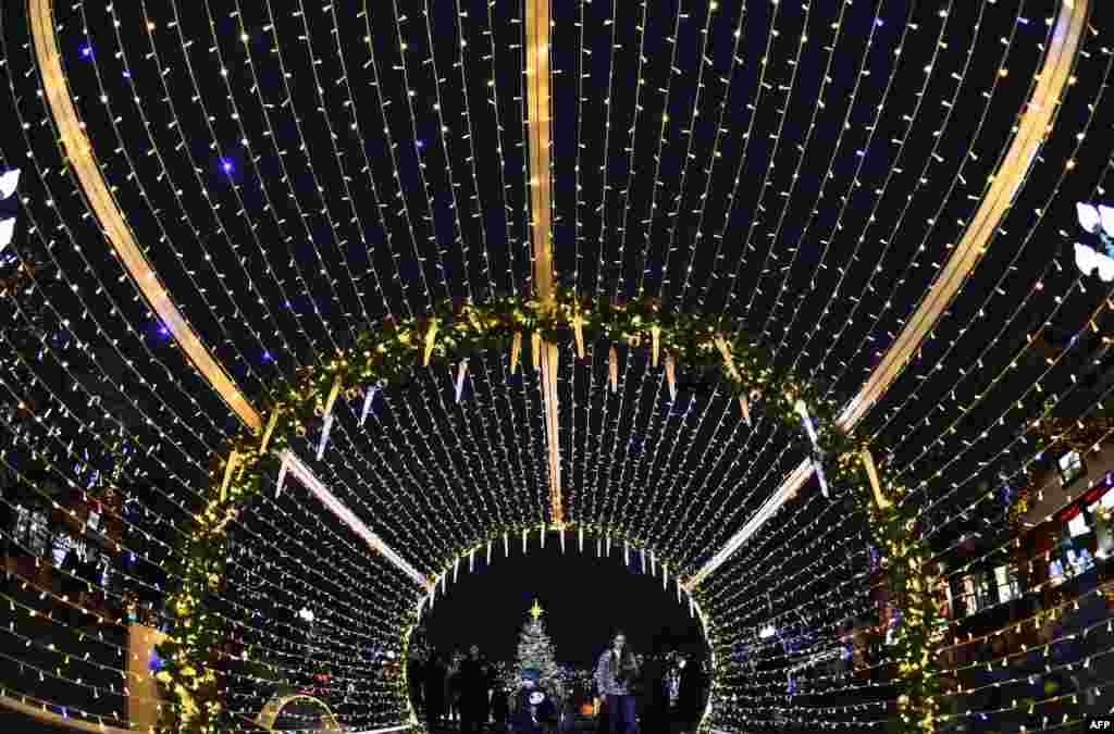 People walk through decorations for the upcoming Christmas and New Year celebrations in central Moscow, Russia.