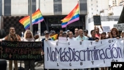 Activistas de la comunidad LGBTI protestan frente al edificio del Ministerio Público. Un total de 33 hombres fueron detenidos durante una fiesta en un club privado para la comunidad LGBTI en Valencia, Estado Carabobo. (Foto de Magda Gibelli / AFP)