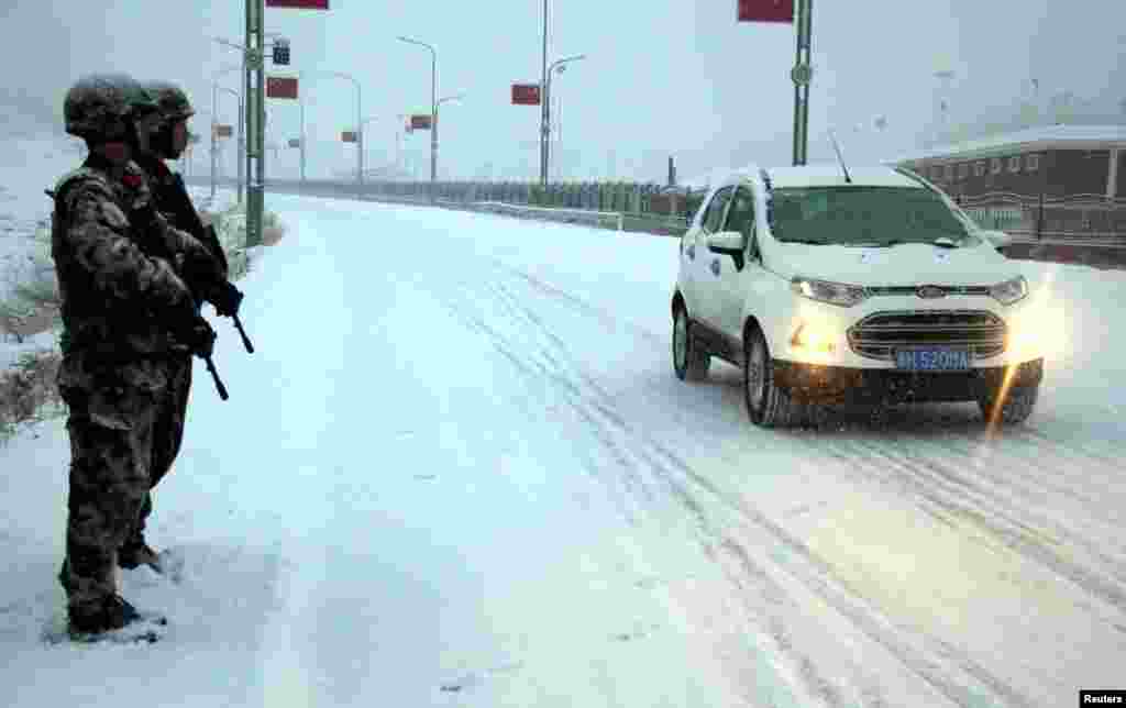 2017年12月27日，中国新疆维吾尔自治区阿勒泰市，军人在大雪中站岗，确保交通安全。