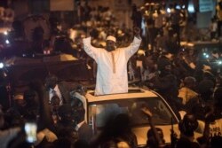 FILE - People cheer as President Adama Barrow arrives in Serrekunda, Gambia, Jan. 26, 2017.