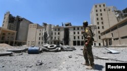 FILE - A Syria Democratic Forces (SDF) fighter walks in the silos and mills of Manbij after the SDF took control of it in Aleppo Governorate, Syria, July 1, 2016.