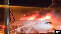 Para petugas pemadam kebakaran memadamkan api yang membakar pesawat Air Busan di Bandara Internasonal Gimhae di Busan, Selasa, 28 Januari 2025. (Foto: Yonhap/AFP)