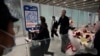 FILE- Passengers walk out of the International arrival hall of the Beijing Capital International Airport in Beijing, March 14, 2023.