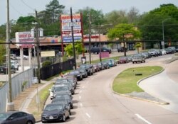 A line of cars stretches over two miles as people wait to enter a drive-thru testing site for COVID-19 at United Memorial Medical Center, March 19, 2020, in Houston, Texas.