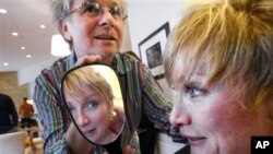 Melissa Rayworth reacts after getting a haircut from Laurent D., left, as she undergoes a makeover at his salon Prive in New York, April 22, 2005. (AP Photo/Bebeto Matthews)