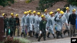 Les secouristes se dirigent vers l'entrée des grottes à Mae Sai, dans la province de Chiang Rai, dans le nord de la Thaïlande, le 10 juillet 2018.