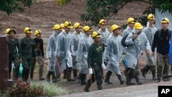 Rescatistas caminan hacia la entrada de una cueva donde permanecen atrapados un niño y su entrenador de fútbol en Mae Sai, en la provincia de Chiang Rai, norte de Tailandia, el martes, 10 de julio de 2018.
