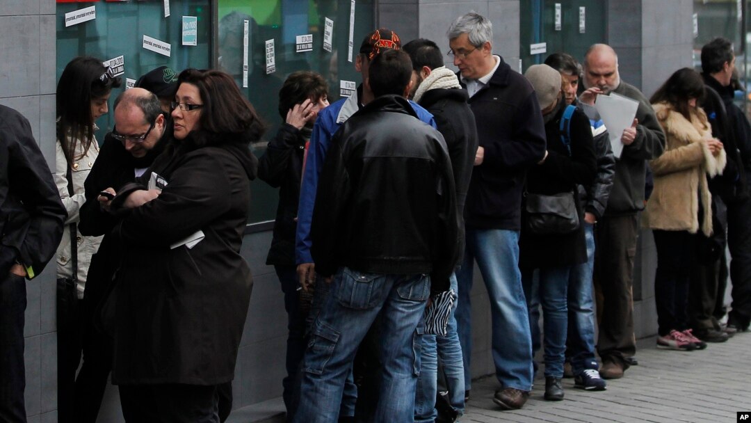 People wait outside an unemployment office in Madrid, Spain, Apr. 2, 2013. 