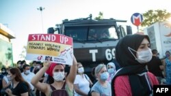 A demonstrator holds up a placard reading 'Stand up against violence towards women' during a demonstration for better protection of the family and prevention of violence against women, in Istanbul, Turkey, Aug. 5, 2020.