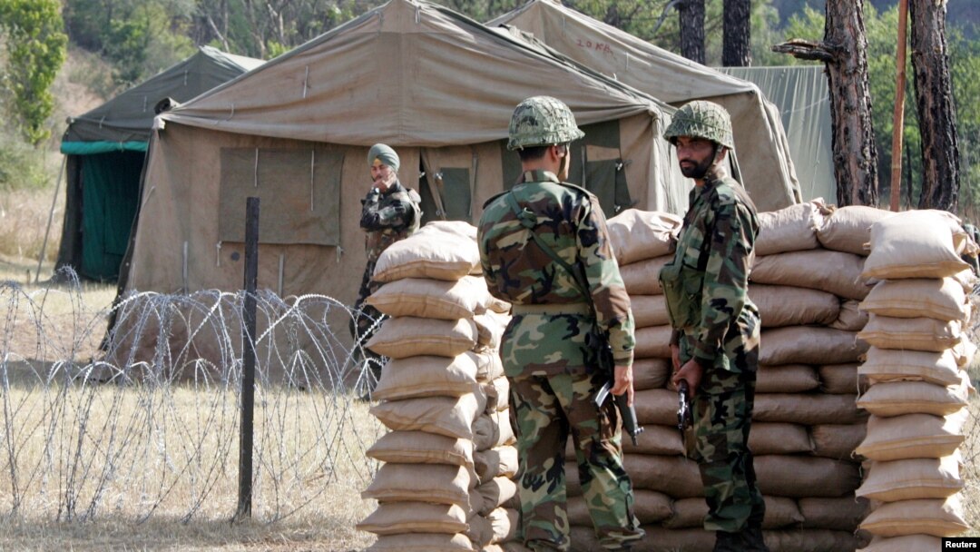 Dua tentara Pakistan berjaga di perbatasan Tatapani, Kashmir, sementara tentara India tampak di seberang perbatasan (foto; dok). 