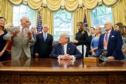 President Donald Trump, accompanied by Apollo 11 astronauts Michael Collins, left, and Buzz Aldrin, with Vice President Mike Pence and first lady Melania Trump, listens during photo opportunity commemorating 50th anniversary of Apollo 11 moon landing