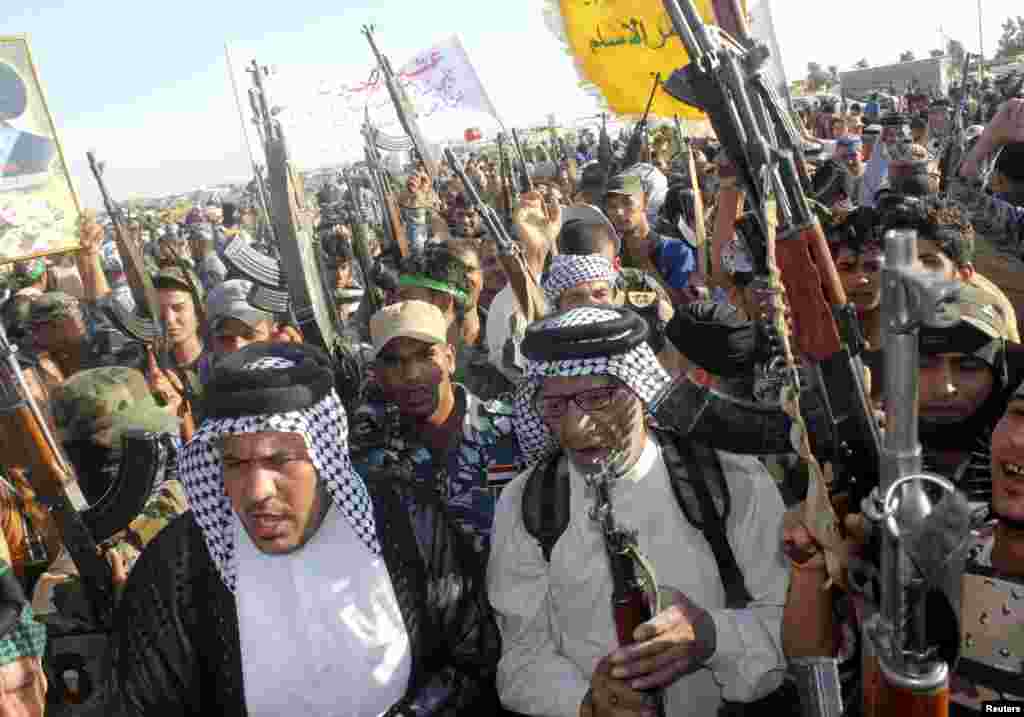 Shi'ite volunteers who joined the Iraqi army to fight against predominantly Sunni militants from the radical Islamic State of Iraq and the Levant take part in a parade in Kanaan, Iraq, June 26, 2014. 