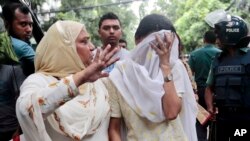 Un proche console Semin Rahman, au visage couvert, dont le fils a disparu lors que lors de la prise d’otages des étrangers dans un restaurant à Dhaka, au Bangladesh, 2 juillet2016. (AP Photo)