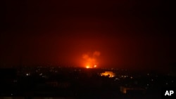An explosion by Israeli airstrikes is seen in Gaza City early Monday, Feb. 24, 2020. Israel's military says it struck Palestinian militants in Gaza and Syria after they fired some 20 rockets toward southern Israel.
