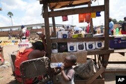 A woman sells small radio sets at a busy local marketplace stall in Harare on February 2, 2023. (AP Photo/Tsvangirayi Mukwazhi)