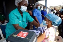 FILE - Hospital staff receives one of the country's first coronavirus vaccinations using AstraZeneca vaccine, provided through the global COVAX initiative, at Yaba Mainland hospital in Lagos, Nigeria, March 12, 2021.