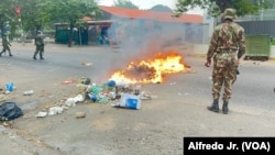 Um militar olha para chamas numa rua de Maputo, capital moçambicana que acordou sob mais um dia de protestos, convocado por Venâncio Mondlane a 7 de novembro.