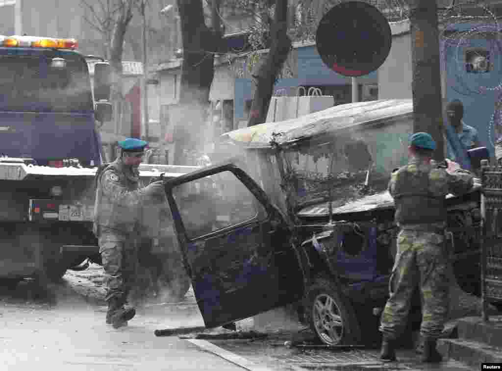 Turkish soldiers take pictures of a vehicle at the site of a suicide attack in Kabul, Feb. 26, 2015.