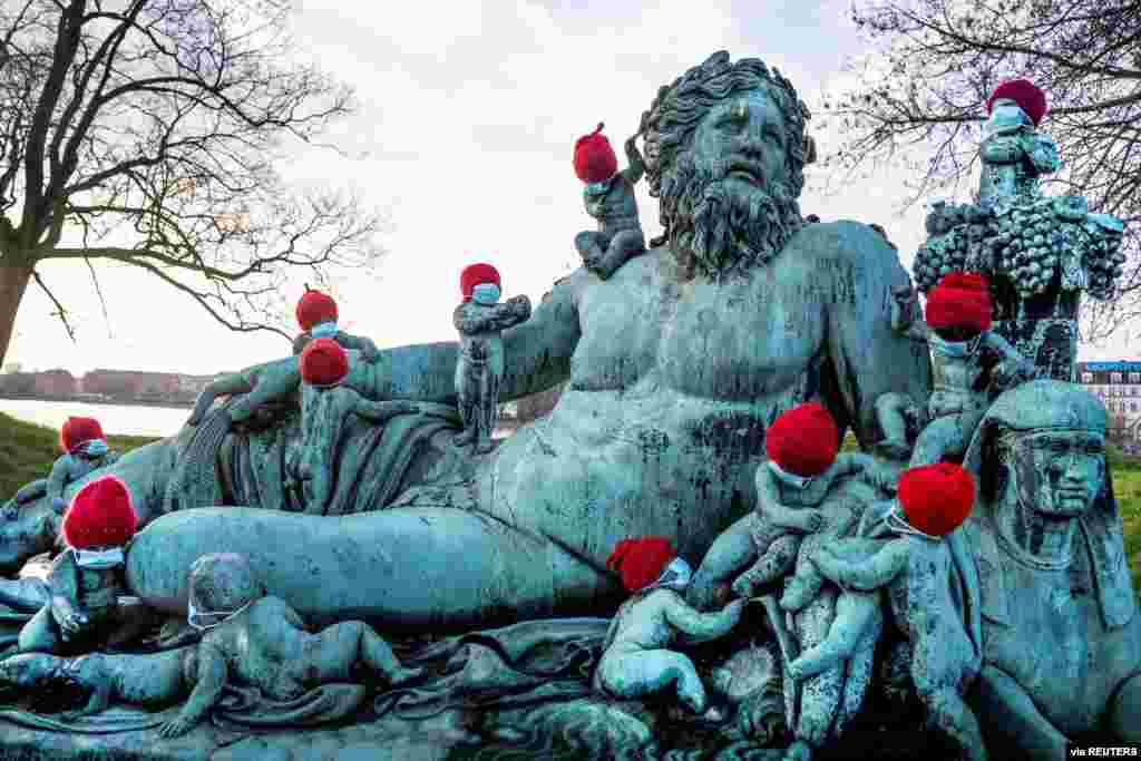 La estatua &quot;Nilen&quot; (el Nilo), que tiene 16 peque&#241;os ni&#241;os de bronce gateando y usando gorros navide&#241;os por la temporada, Copenhague, Dinamarca, el 16 de diciembre de 2020. [Reuters].