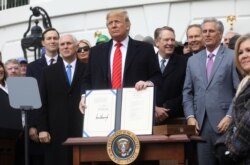 도널드 트럼프 미국 대통령이 지난 1월 29일 워싱턴DC 백악관에서 미국·멕시코·캐나다협정(USMCA)에 서명한 뒤 서명서를 들어보이고 있다.