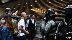 Para pendemo berhadapan dengan polisi dalam demonstrasi di kawasan bisnis Central di Hong Kong, 11 November 2019. (Foto: AFP)