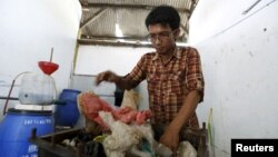 Hamidi menaruh limbah plastik ke dalam kotak besi sebelum membakar dan mengubahnya menjadi bahan bakar di TPA Rawa Kucing, Tangerang, Banten (17/3). (Reuters/Beawiharta)