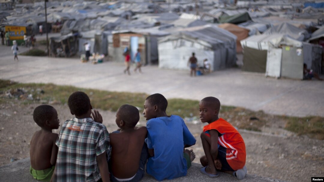 Sekelompok bocah laki-laki duduk di atas atap rumah yang hancur karena gempa Haiti 2010, di seberang sebuah kamp yang mereka tinggali di Port-au-Prince, Januari 2013. (Foto: Dok)