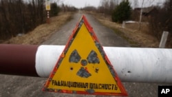 In this Tuesday, March 22, 2011 a sign reads 'Radiation danger' in the state radiation ecology reserve in the village of Babchin, near the 30 km exclusion zone around the Chernobyl nuclear reactor, some 370 km ( 231 miles) south-east of Minsk, Belarus. Th