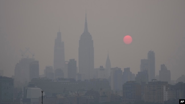 The sun rises over a hazy New York City skyline as seen from Jersey City, N.J., Wednesday, June 7, 2023. Intense Canadian wildfires are blanketing the northeastern U.S. in a dystopian haze, turning the air acrid, the sky yellowish gray and prompting warnings for vulnerable populations to stay inside. (AP Photo/Seth Wenig)