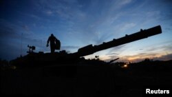 An Israeli soldier walks on an Israeli tank near the Israel-Gaza border, amid the temporary truce between Hamas and Israel, in southern Israel, Nov. 28, 2023. 