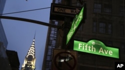 FILE - Signs for Fifth Avenue and 42nd Street and the Chrysler Building are illuminated, in New York City, Nov. 18, 2013.