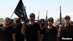 Islamist fighters carry their flag during the funeral of their fellow fighter Tareq Naser, who died during clashes on Sunday, near the village of Fafeen in Aleppo's countryside September 17, 2012.