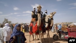 Des chameliers et d’autres piétons dans une rue de Ménaka, au Mali, le 9 mai 2018.