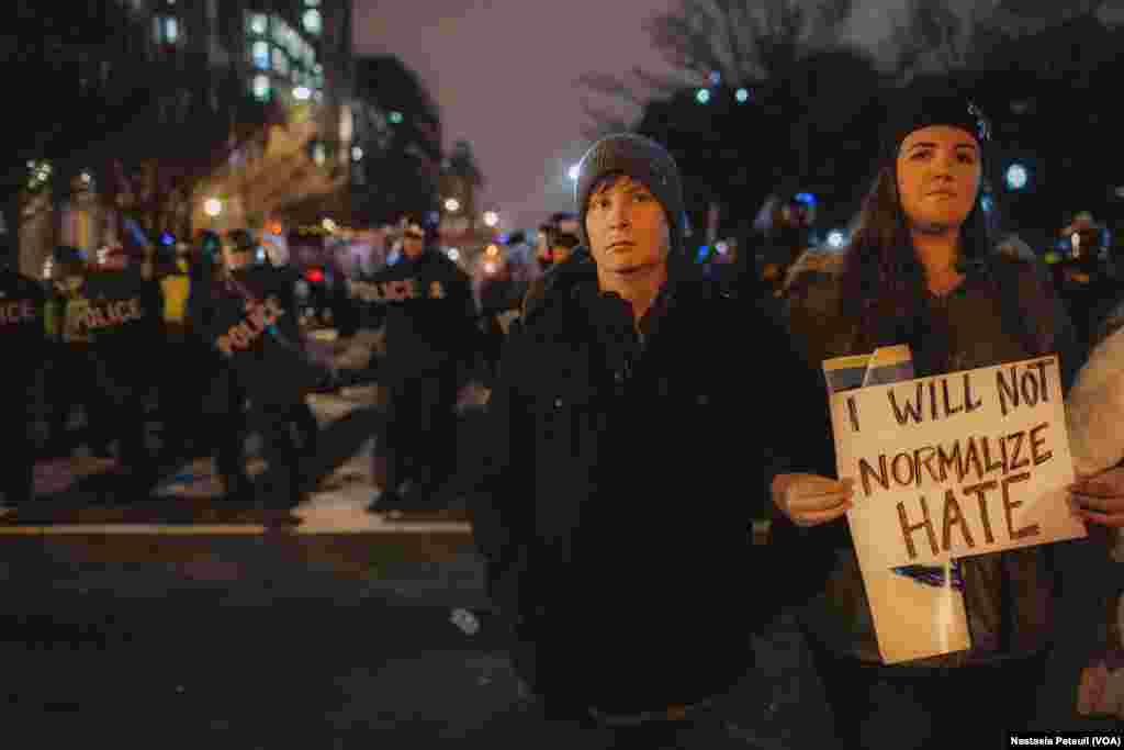 Sur la place Franklin, des militants anti-Trump se tiennent devant la police, à Washington DC, le 20 janvier 2017. (VOA/Nastasia Peteuil)