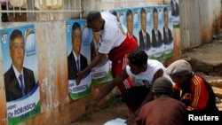 Supporters paste campaign posters of Madagascar's presidential candidate Robinson Jean-Louis along the streets of the capital, Antananarivo, October 23, 2013.