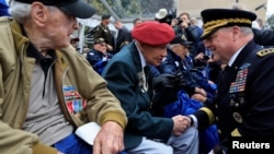 U.S. General Mark A. Milley talks to World War II veterans during a ceremony at the World War II Normandy American Cemetery and Memorial situated above Omaha Beach in Colleville-sur-Mer, on the Normandy coast to commemorate the 79th anniversary of the D-Day, France, June 6, 2023. REUTERS/Pascal Rossignol