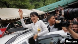 Aung San Suu Kyi waves to people who have gathered to meet her at the Mae La refugee camp, where tens of thousands of her compatriots live, near Mae Sot at the Thai-Burmese border June 2, 2012.