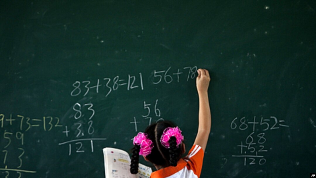 A girl writes on a chalkboard during a math class at Dongba Experimental School, a school for the children of migrant workers, in Beijing, August 25, 2011.
