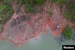 A drone view shows paleontologist Rodrigo Temp Muller and geologist Jossano de Rosso Morais searching for fossils in the city of Paraiso do Sul, of Rio Grande do Sul state, Brazil, October 9, 2024. (REUTERS/Diego Vara)