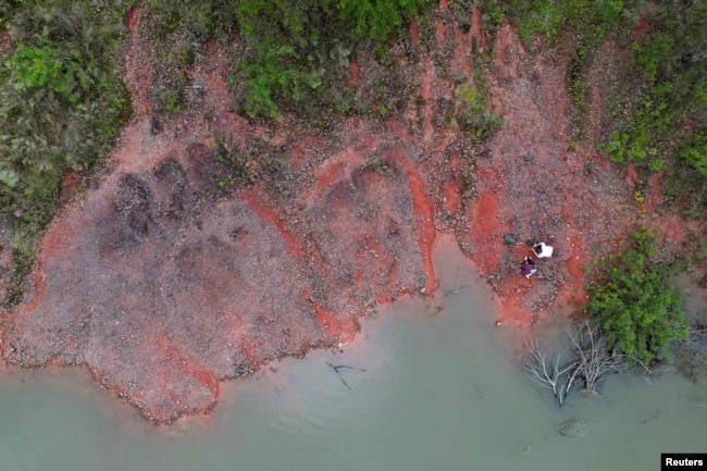 A drone view shows paleontologist Rodrigo Temp Muller and geologist Jossano de Rosso Morais searching for fossils in the city of Paraiso do Sul, of Rio Grande do Sul state, Brazil, October 9, 2024. (REUTERS/Diego Vara)