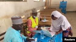 FILE - A voter signs after casting her ballot during the first regional election in Maroua, Cameroon, Dec. 6, 2020. 